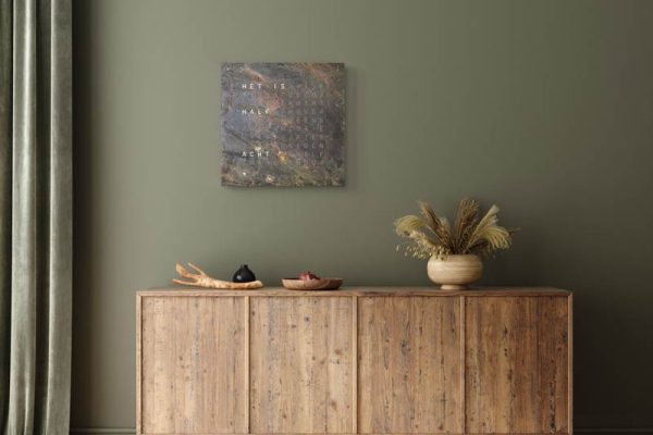 QLOCKTWO woordklok aan de wand boven een dressoir
