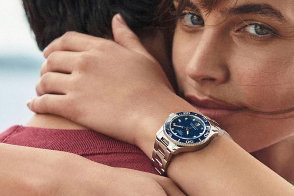 Persoon draagt een Tissot horloge met blauwe wijzerplaat
