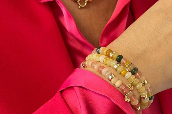 Vrouw draagt Y&G collier en armbanden met kleurige edelstenen