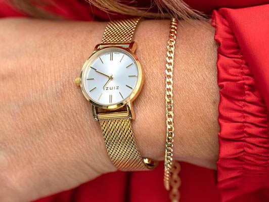Pols met gouden Zinzi horloge met mesh band en armband
